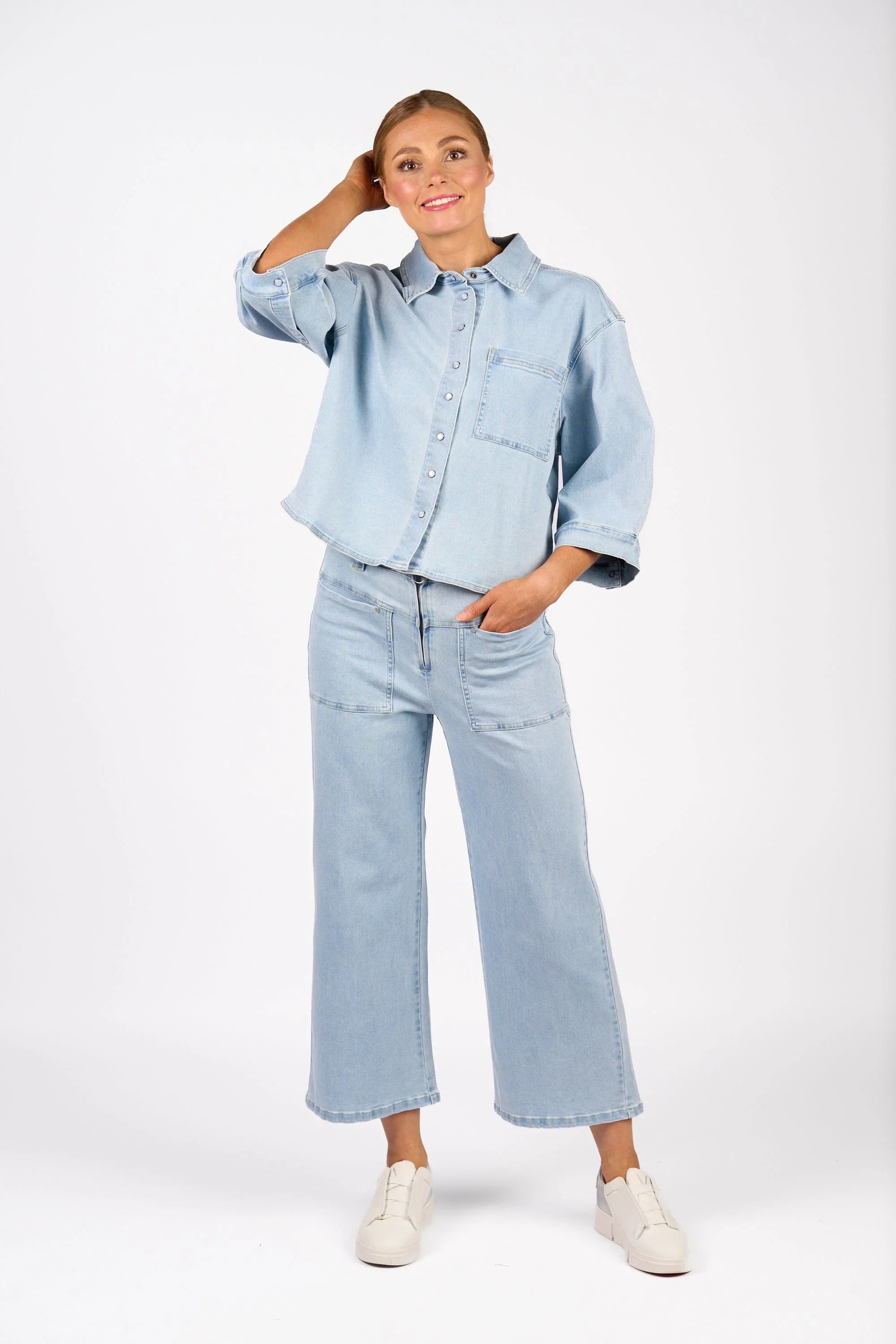 Woman modeling light wash denim shacket and wide leg jeans on white background