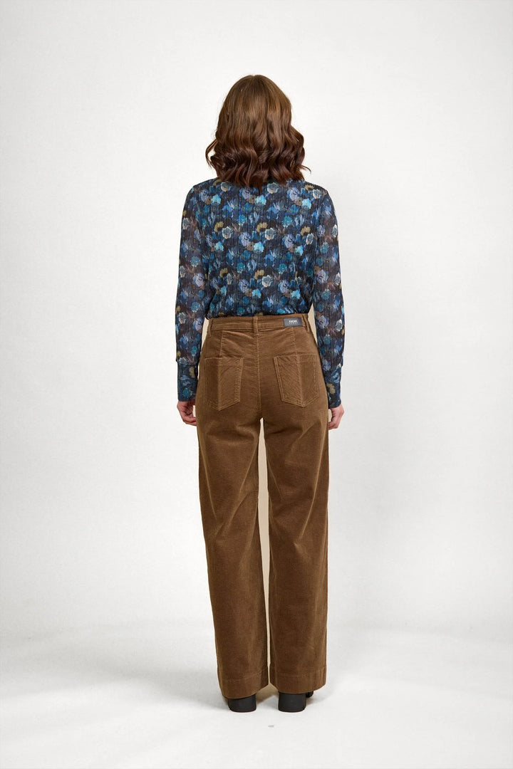 Brown corduroy wide-leg pants with back pockets, paired with floral long-sleeve top