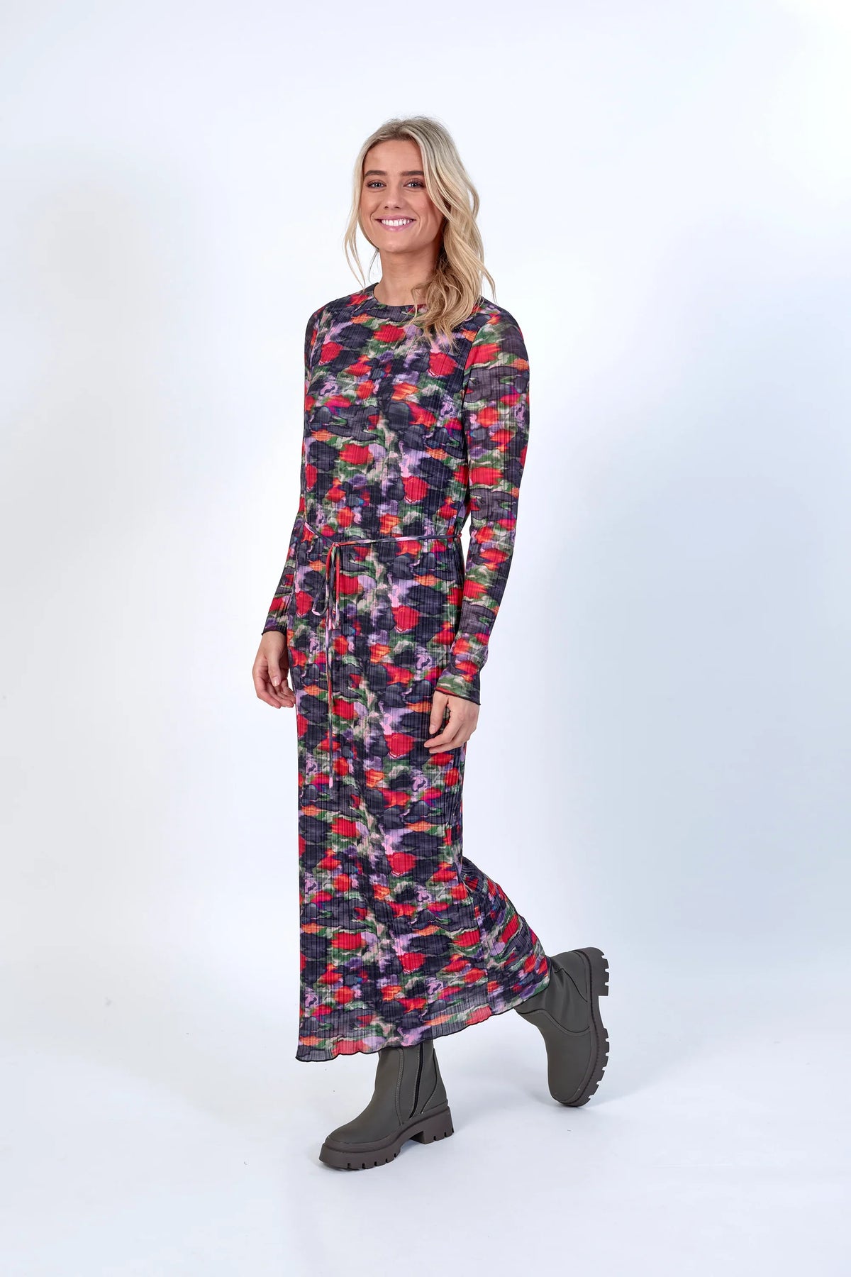 Woman wearing a long sleeve, floral print maxi dress with belt and chunky boots