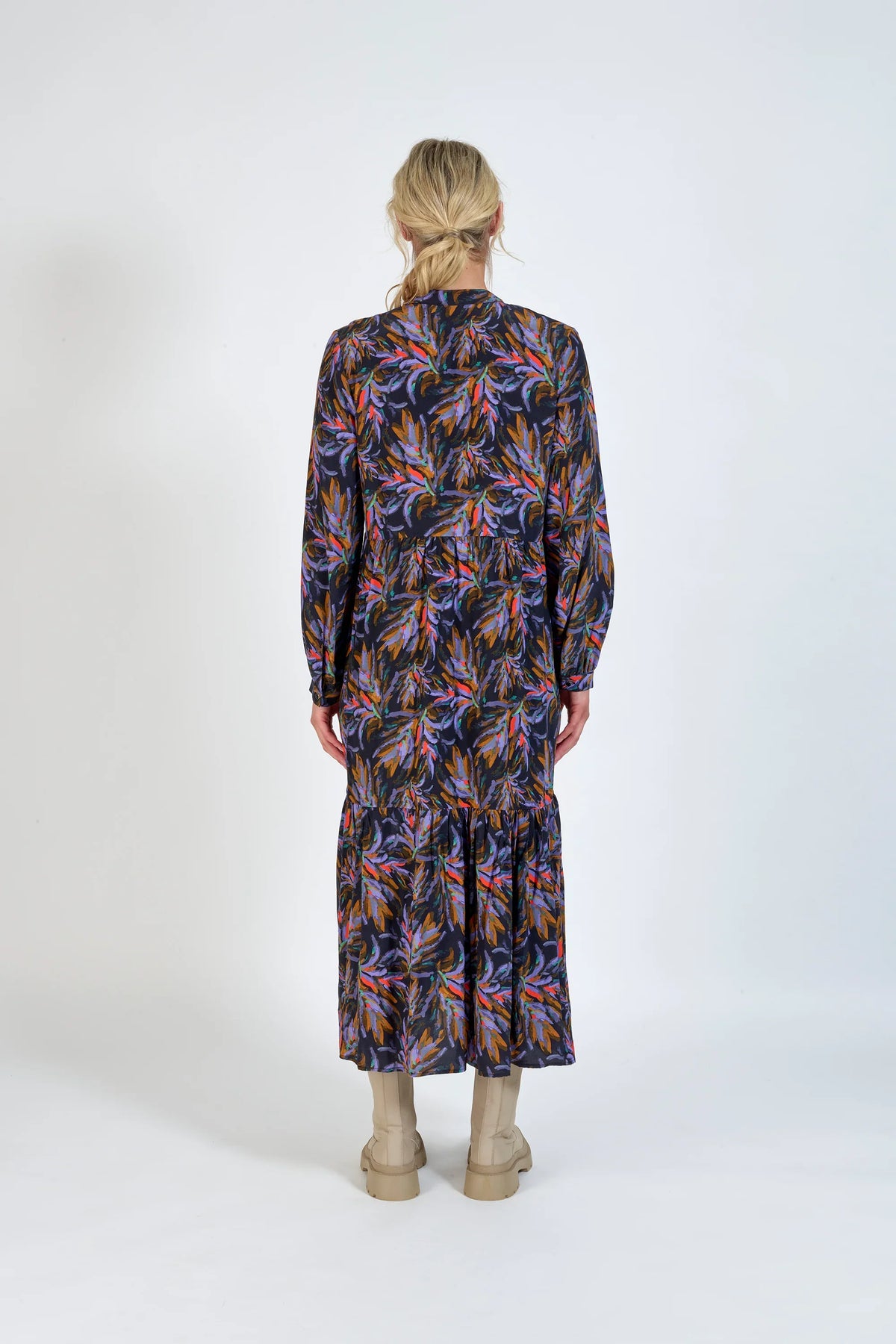 Back view of a woman wearing a long-sleeve floral midi dress with boots