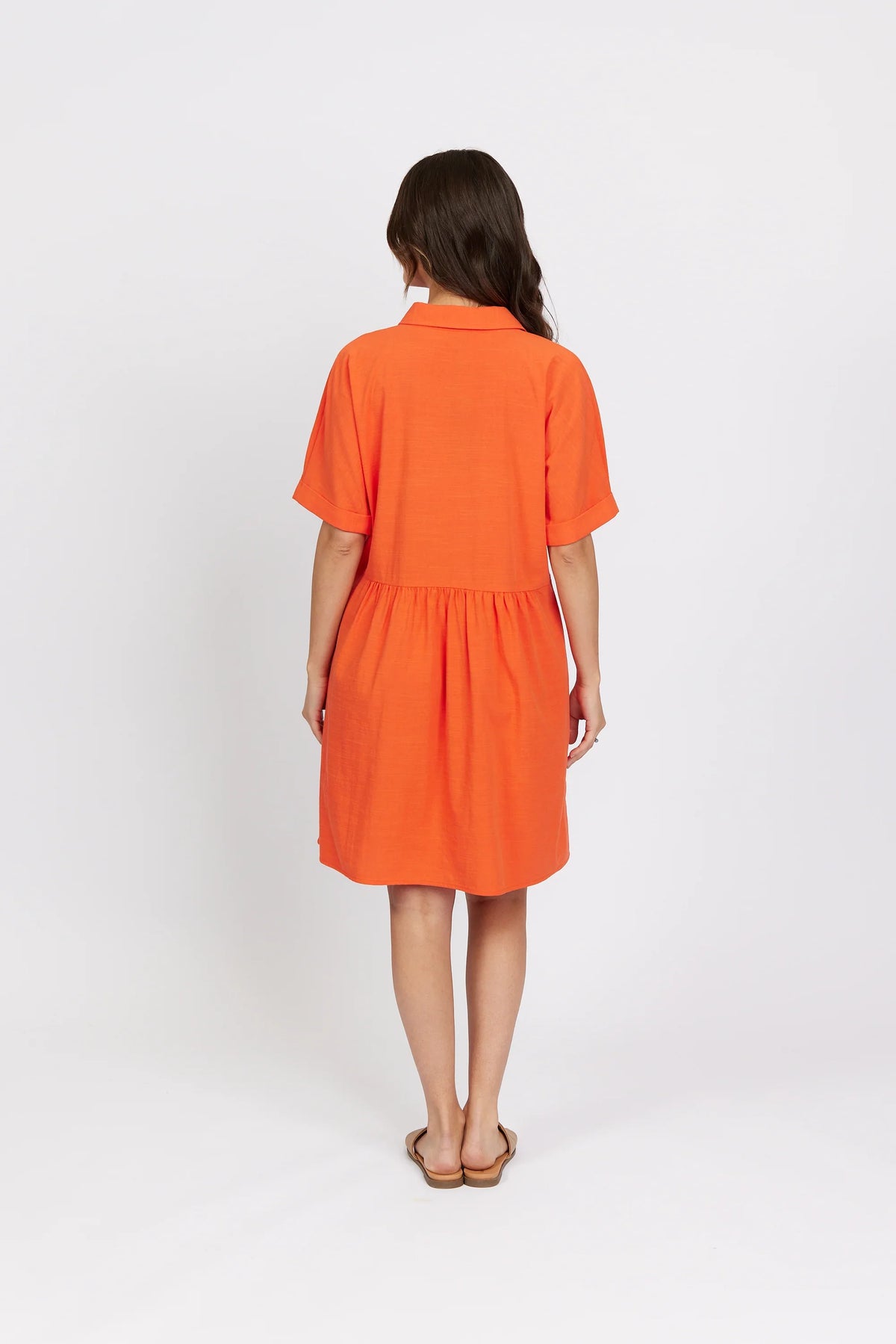 Back view of woman wearing short sleeve orange cocoon dress, casual style