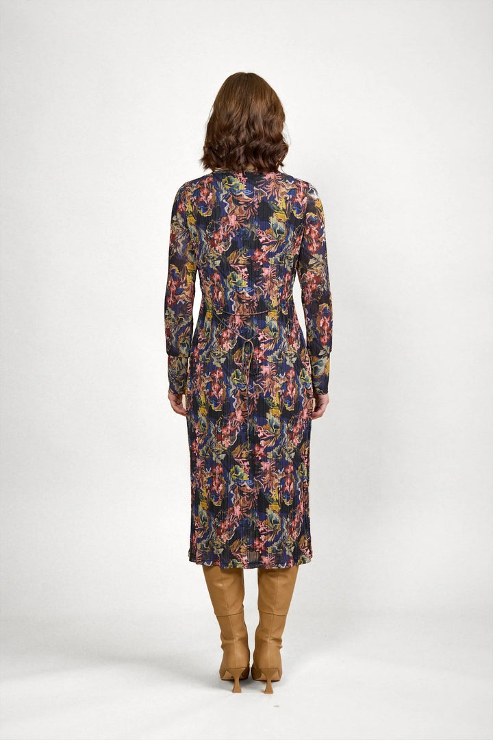 Back view of woman in long sleeve, floral print midi dress with tan boots