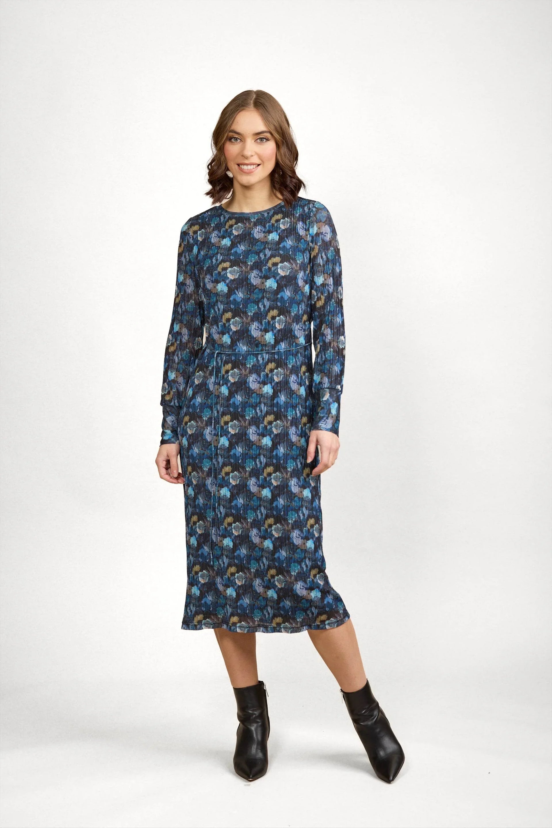 Woman wearing a long-sleeve floral print midi dress in blue tones with black ankle boots