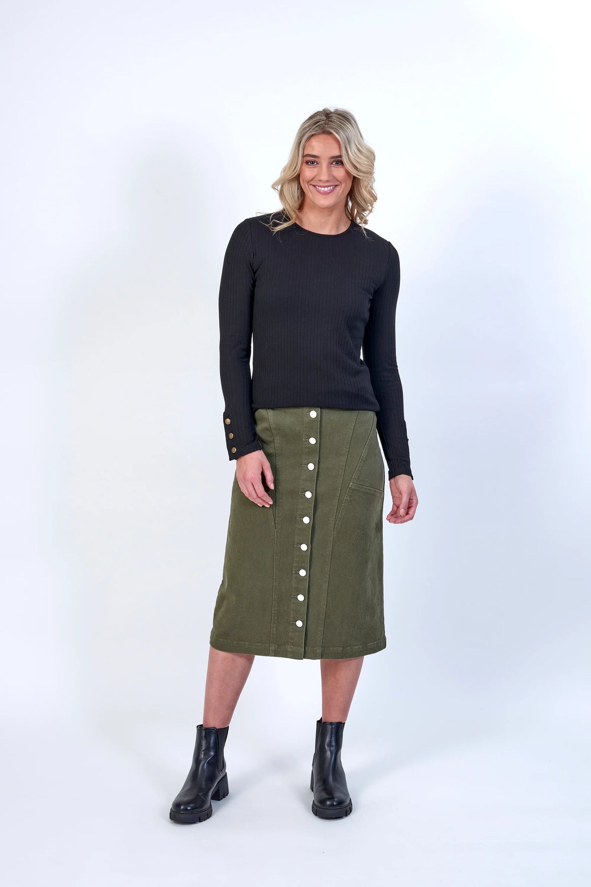Woman modeling a black ribbed long sleeve top with gold button details, casual outfit