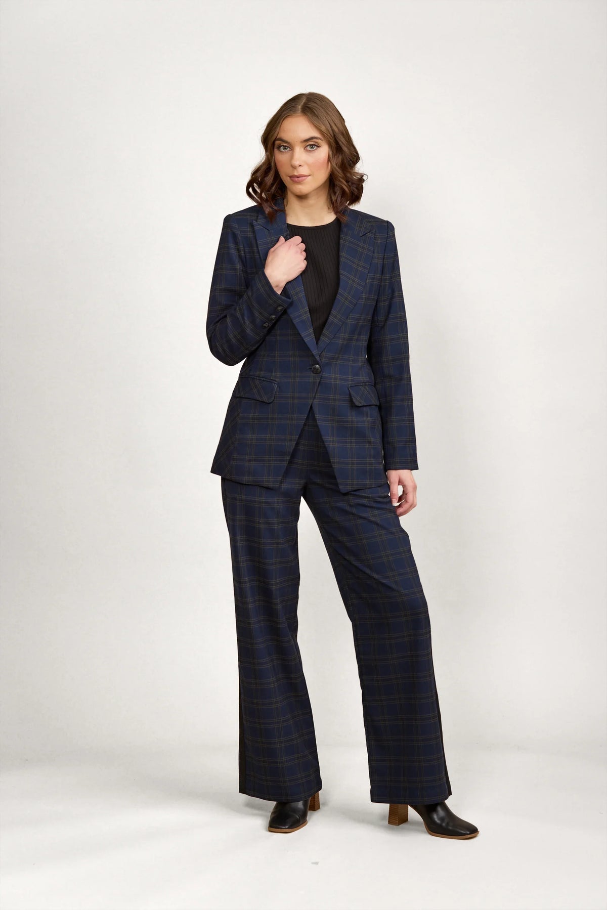 Woman modeling navy check blazer and matching wide-leg pants set with black boots