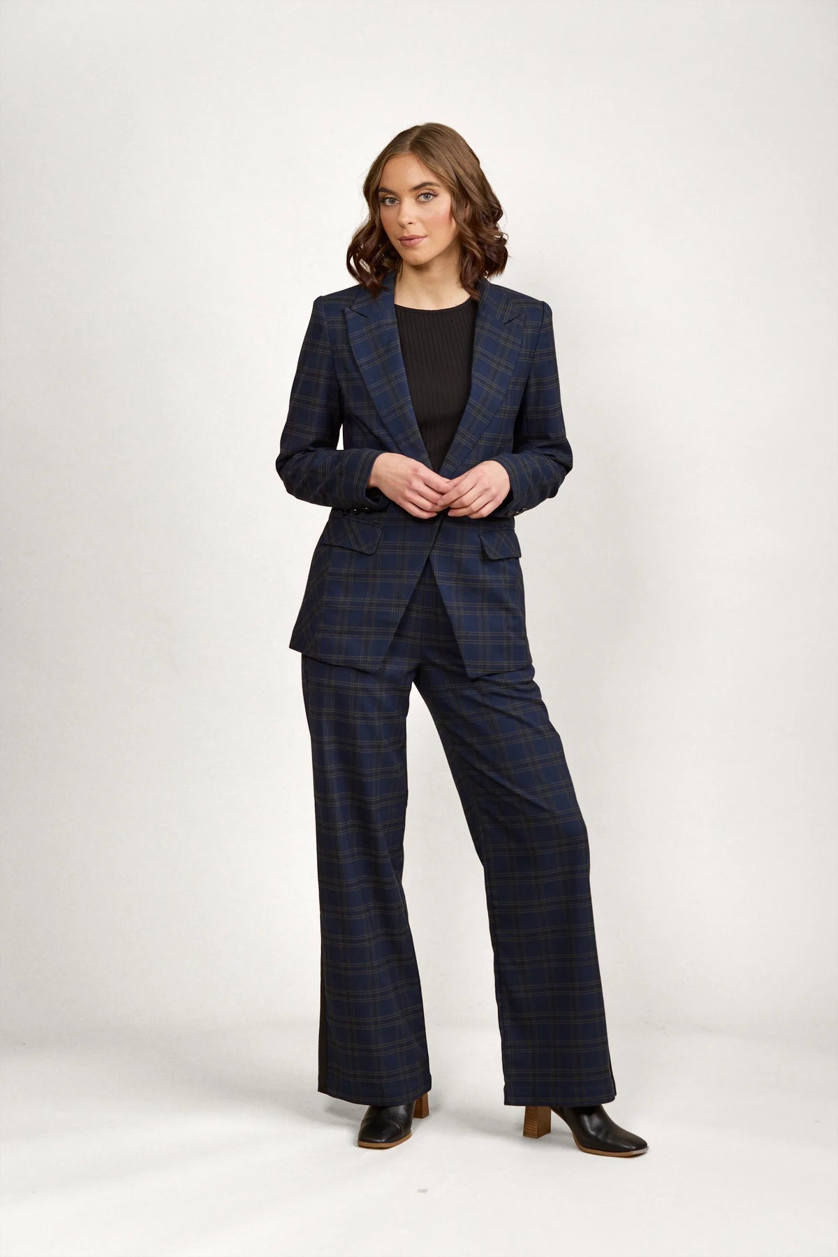 Woman wearing a tailored navy plaid blazer and matching wide-leg pants set