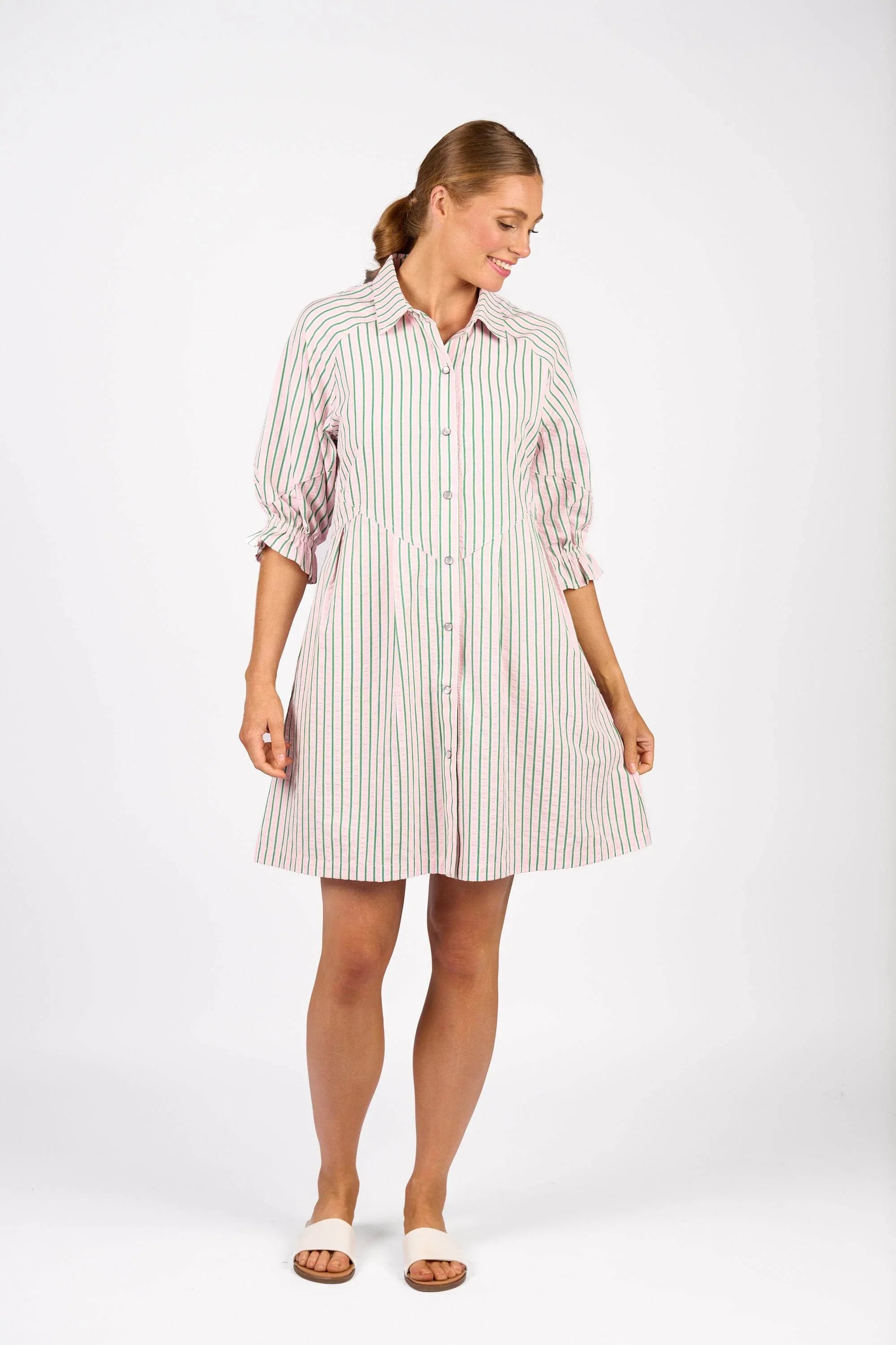 Woman wearing a striped button-down shirt dress with three-quarter sleeves, summer fashion